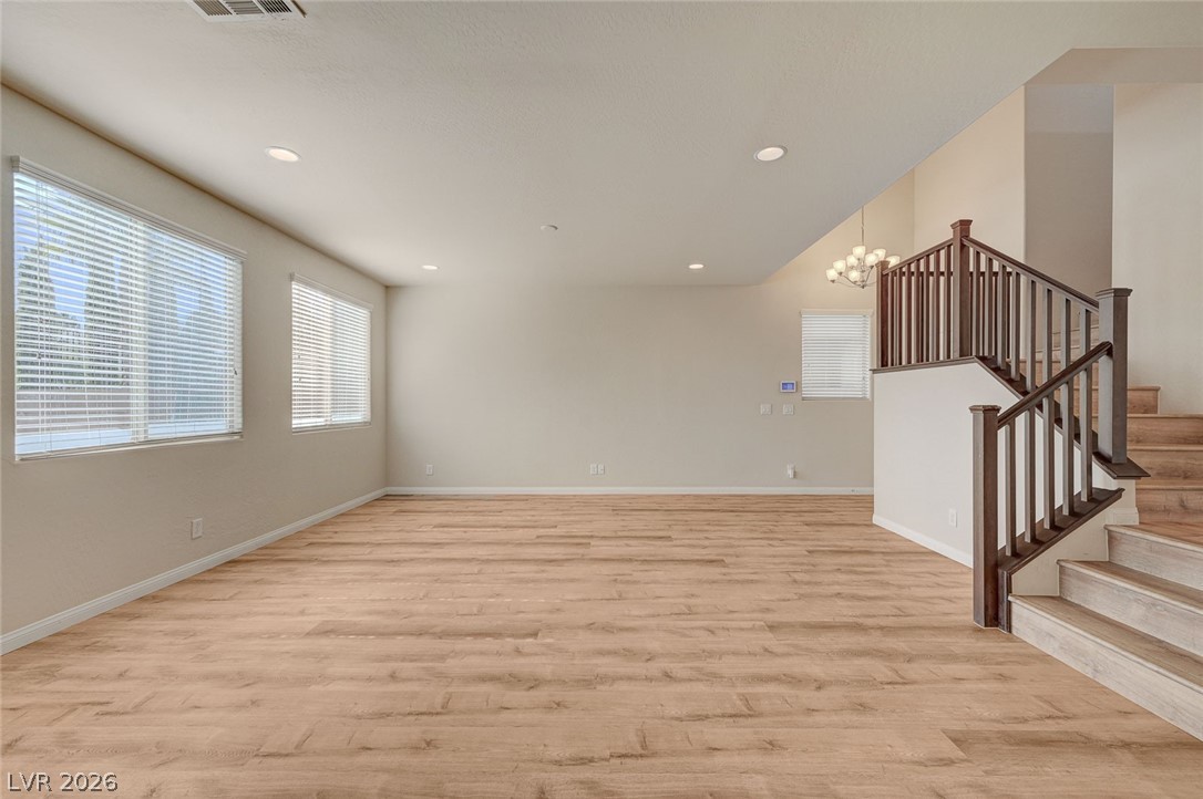 113 Elm Reed Avenue Las Vegas, NV 89113 - Photo 13 of 62 Spare room featuring healthy amount of natural light, light wood-style flooring, and a chandelier