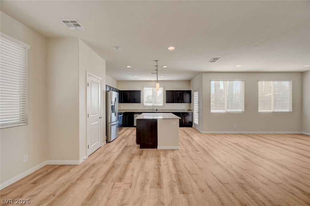 113 Elm Reed Avenue Las Vegas, NV 89113 - Photo 62 of 62 Kitchen featuring open floor plan, a center island, light countertops, decorative light fixtures, and light wood-type flooring