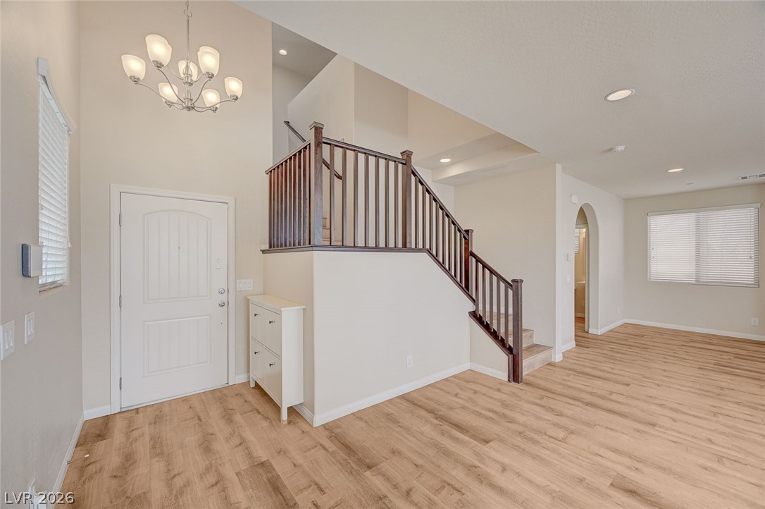 113 Elm Reed Avenue Las Vegas, NV 89113 - Photo 25 of 62 Foyer featuring arched walkways, light wood-type flooring, suspended lighting, and a high ceiling
