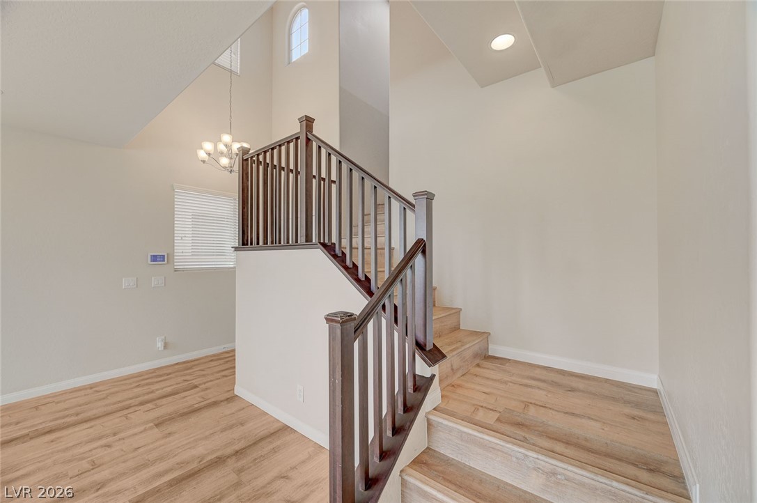 113 Elm Reed Avenue Las Vegas, NV 89113 - Photo 26 of 62 Stairs with a high ceiling, a chandelier, and wood finished floors