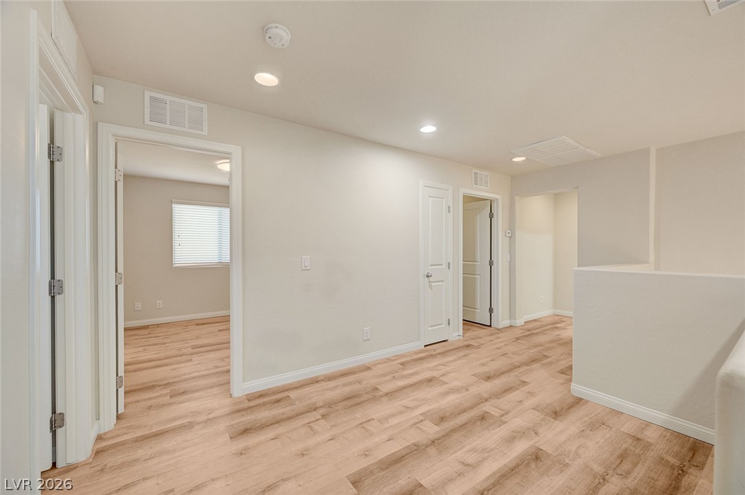 113 Elm Reed Avenue Las Vegas, NV 89113 - Photo 27 of 62 Empty room with light wood-style floors and recessed lighting