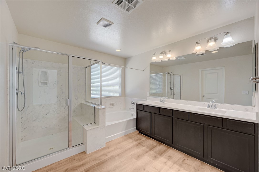 113 Elm Reed Avenue Las Vegas, NV 89113 - Photo 34 of 62 Full bath featuring a marble finish shower, double vanity, a bath, and light wood-style floors