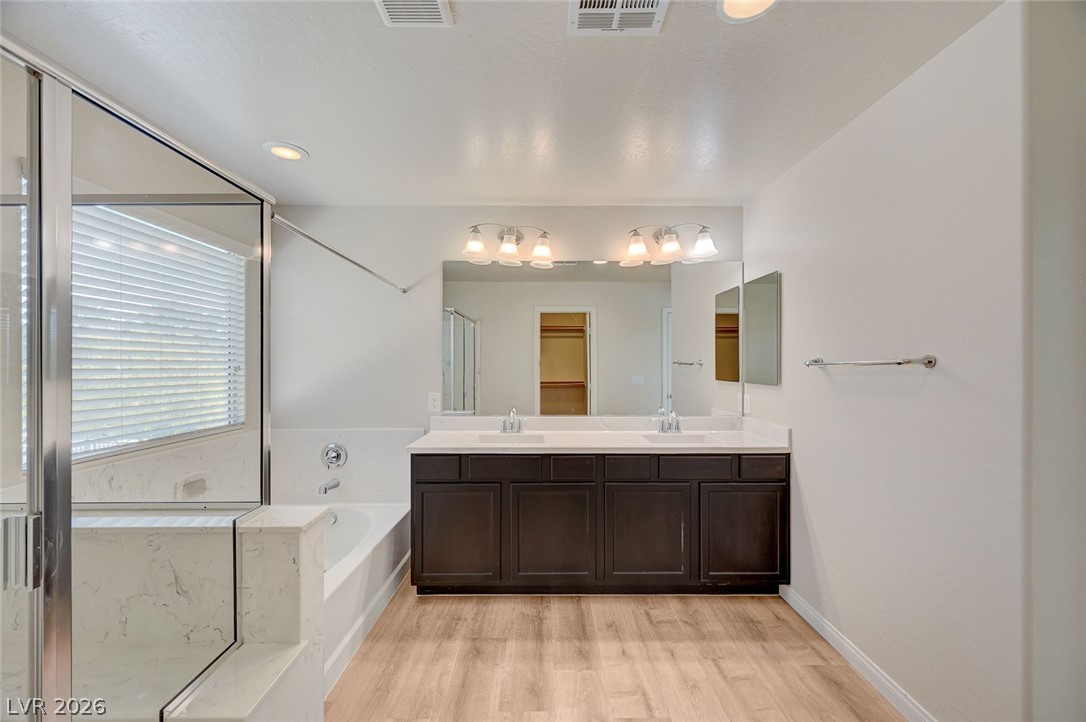 113 Elm Reed Avenue Las Vegas, NV 89113 - Photo 35 of 62 Full bathroom featuring double vanity, a bath, a stall shower, light wood-style floors, and recessed lighting