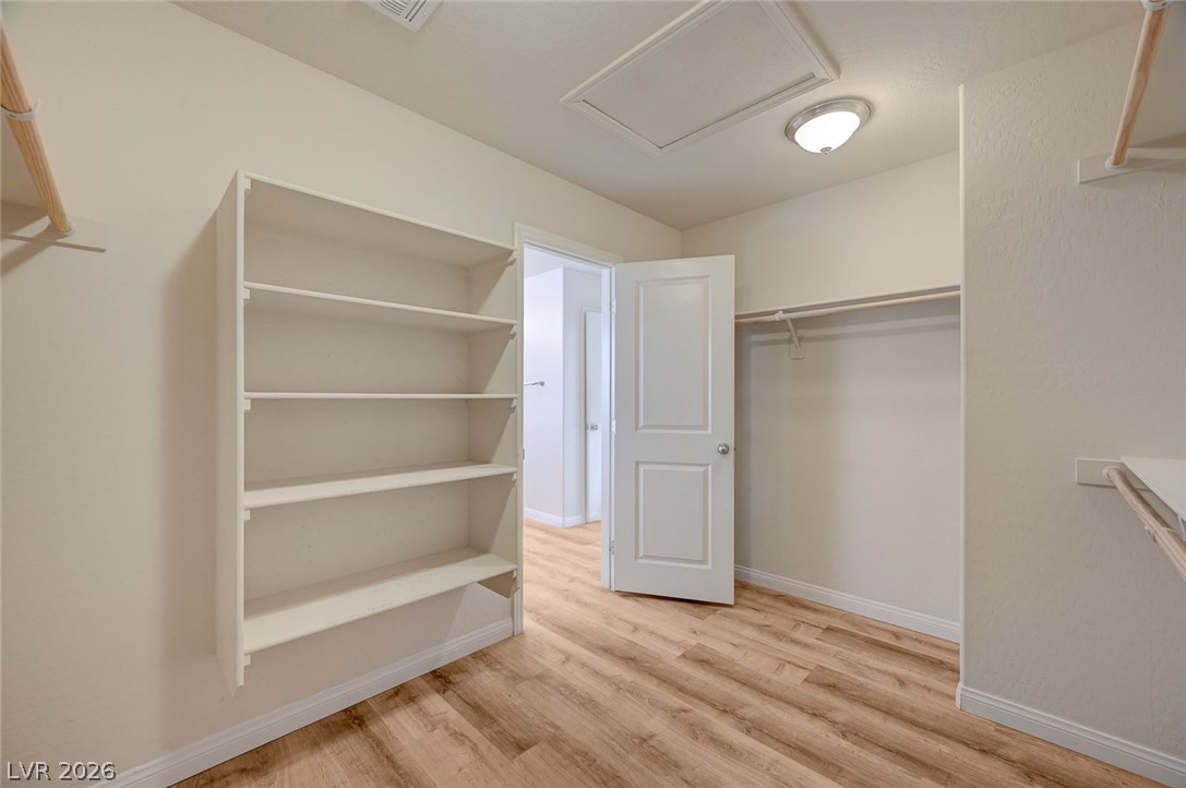 113 Elm Reed Avenue Las Vegas, NV 89113 - Photo 38 of 62 Walk in closet featuring attic access and light wood-type flooring
