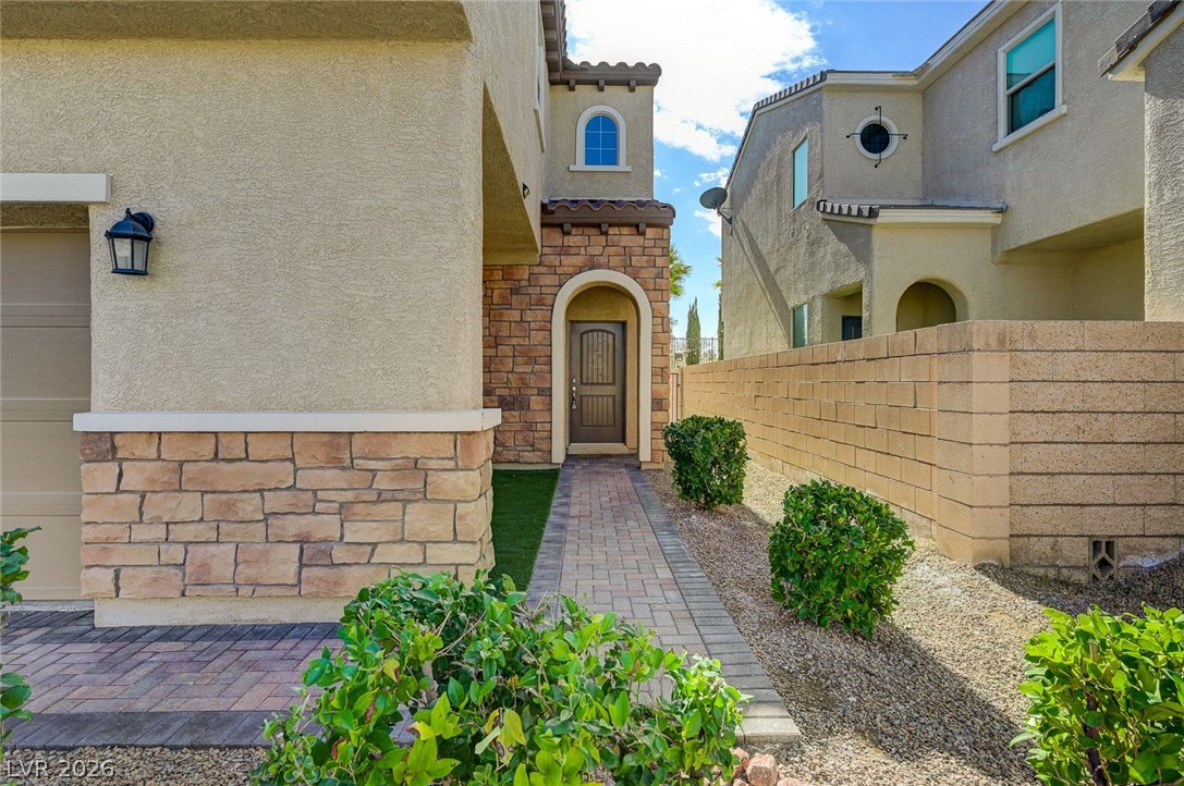 113 Elm Reed Avenue Las Vegas, NV 89113 - Photo 4 of 62 Property entrance with stucco siding, stone siding, and a tiled roof