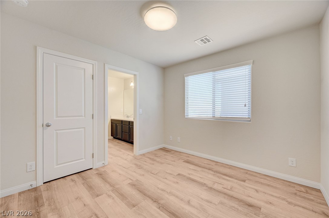 113 Elm Reed Avenue Las Vegas, NV 89113 - Photo 40 of 62 Unfurnished bedroom with connected bathroom and light wood-style floors