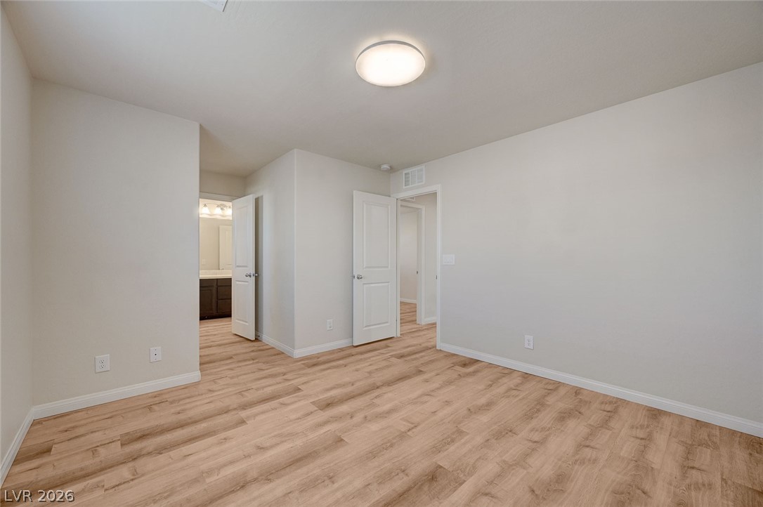 113 Elm Reed Avenue Las Vegas, NV 89113 - Photo 43 of 62 Unfurnished bedroom featuring light wood finished floors and ensuite bath