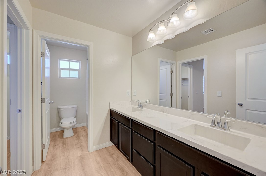 113 Elm Reed Avenue Las Vegas, NV 89113 - Photo 45 of 62 Bathroom featuring double vanity and light wood-style floors