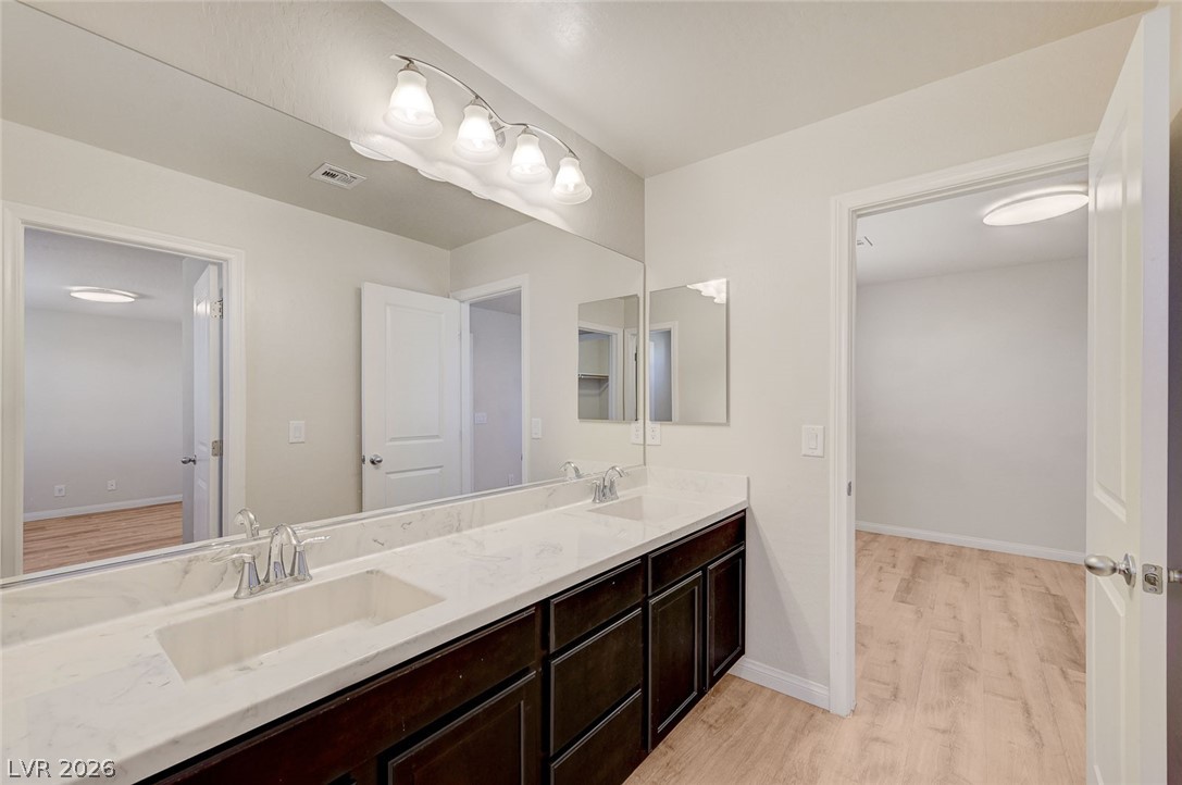 113 Elm Reed Avenue Las Vegas, NV 89113 - Photo 46 of 62 Bathroom with double vanity and light wood-style flooring