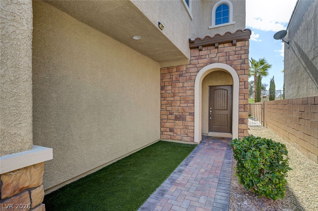 113 Elm Reed Avenue Las Vegas, NV 89113 - Photo 5 of 62 Doorway to property with stone siding and stucco siding
