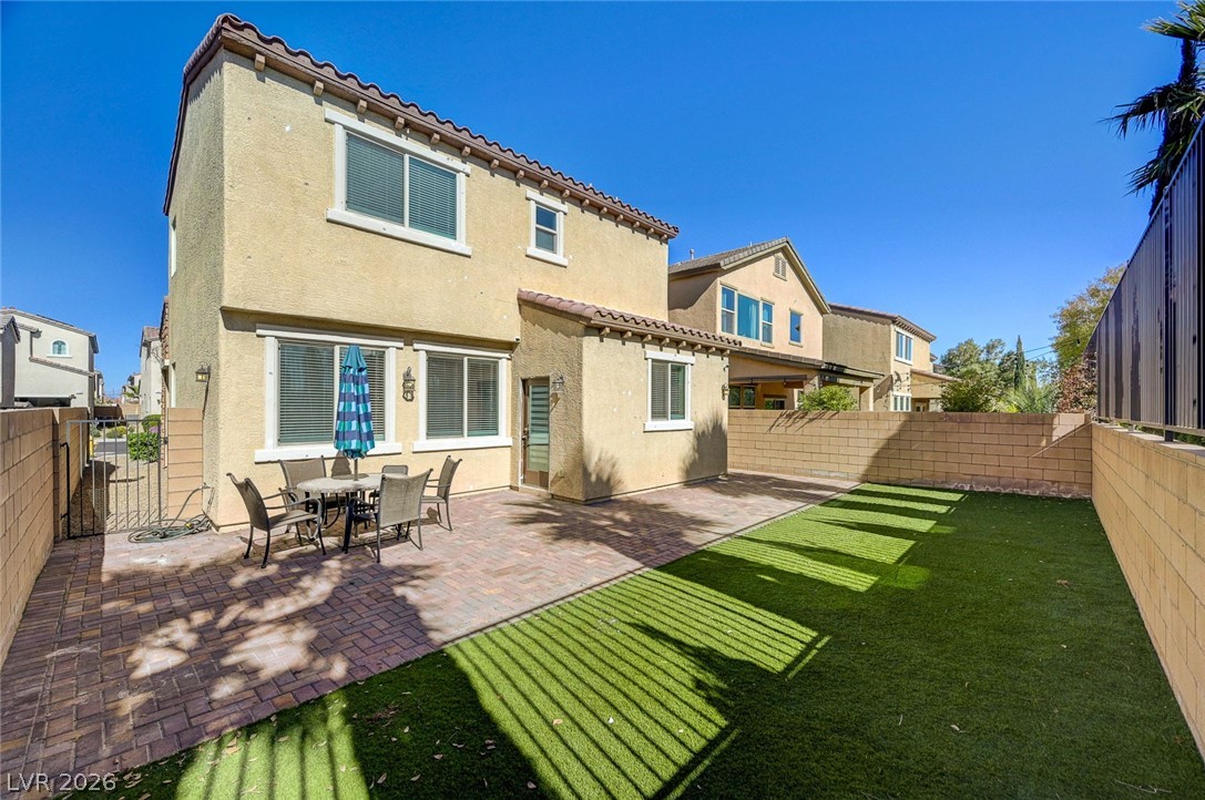 113 Elm Reed Avenue Las Vegas, NV 89113 - Photo 54 of 62 Rear view of property with a fenced backyard, stucco siding, outdoor dining space, a patio area, and a gate