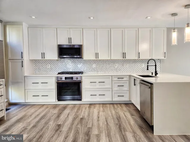 a kitchen with stainless steel appliances a refrigerator and wooden floor