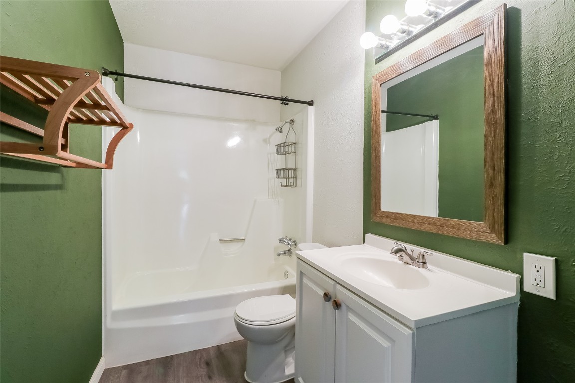 2803 Cornish Circle Austin, TX 78745 - Photo 8 of 16 Bathroom with vanity, washtub / shower combination, dark wood finished floors, and a textured wall