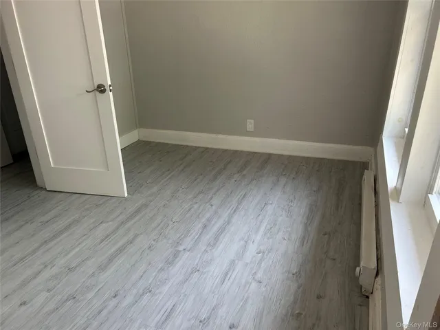 an empty room with wooden floor and entrance