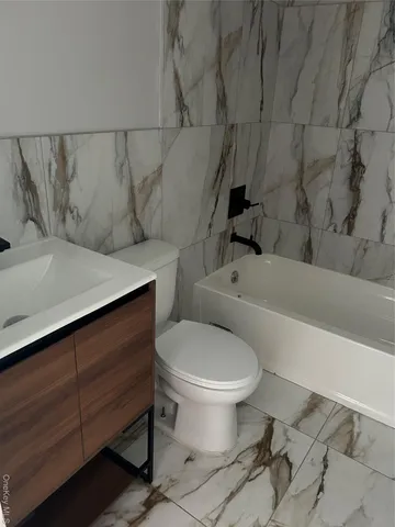 a white toilet sitting next to a bath tub