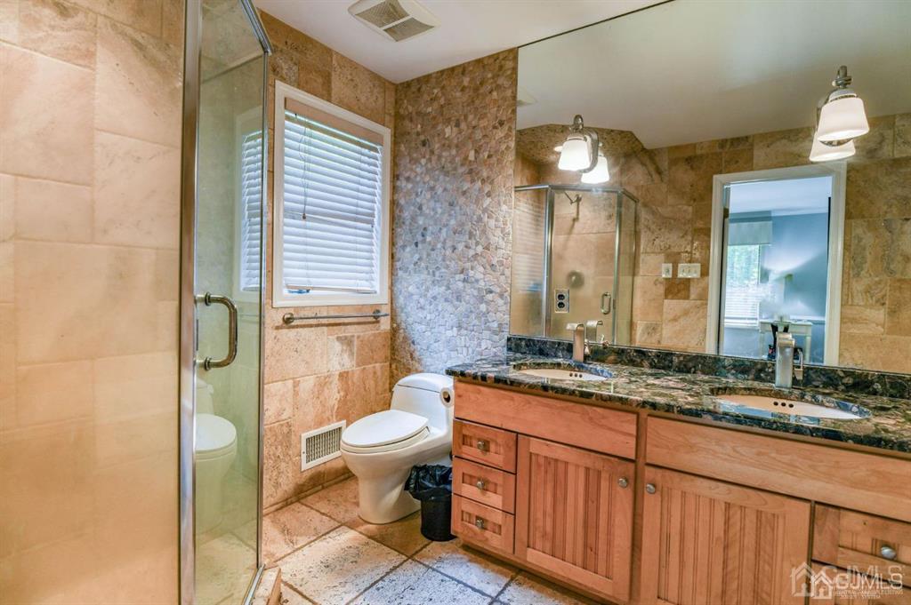 59 Friendship Road Cranbury, NJ 08512 - Photo 21 of 31 a bathroom with a granite countertop sink toilet a mirror and shower