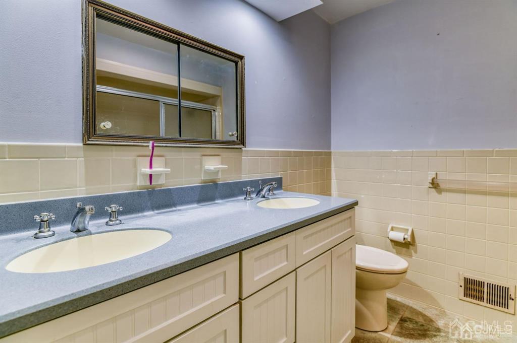 59 Friendship Road Cranbury, NJ 08512 - Photo 28 of 31 a bathroom with a granite countertop sink a toilet and a mirror