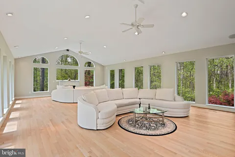 a living room with furniture a large window with kitchen view