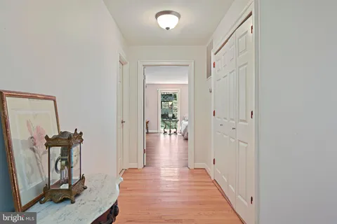 a spacious bedroom with a bed a dresser with wooden floor