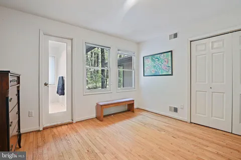 a bedroom with a bed and a dresser next to a window