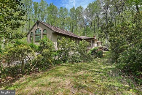 a view of a house with large trees and a barn