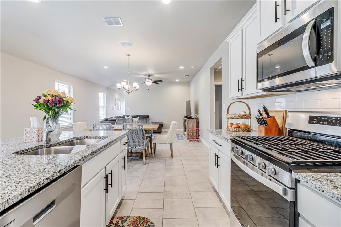 7630 Shadow Rider Lane Corpus Christi, TX 78414 - Photo 18 of 39 a kitchen with kitchen island granite countertop a sink a stove and cabinets