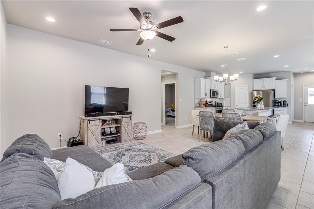 7630 Shadow Rider Lane Corpus Christi, TX 78414 - Photo 9 of 39 a living room with furniture and a flat screen tv with kitchen view