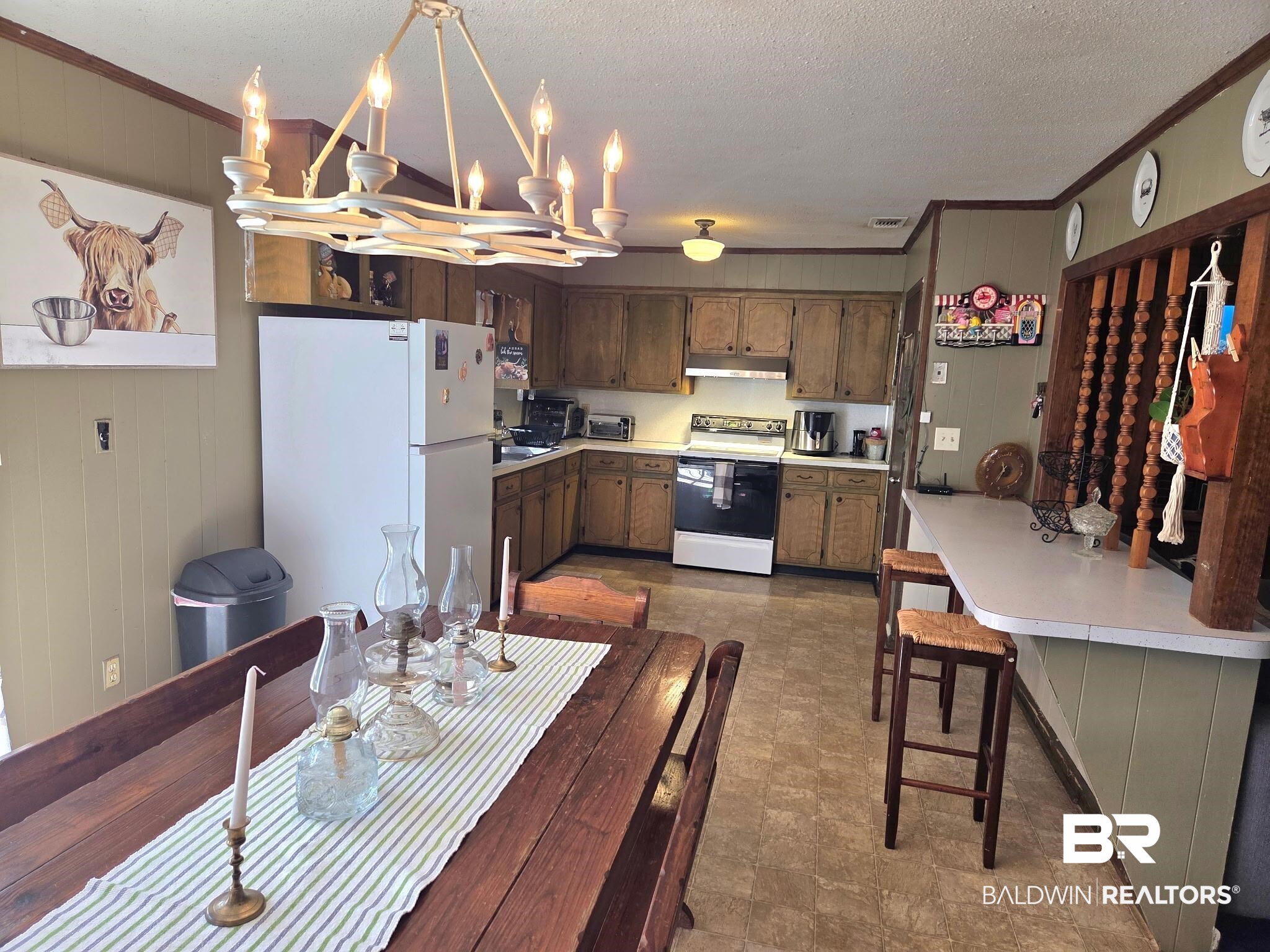 491 Forrest Avenue Castleberry, AL 36432 - Photo 5 of 33 Kitchen with a chandelier, wood walls, crown molding, light countertops, and range with electric stovetop