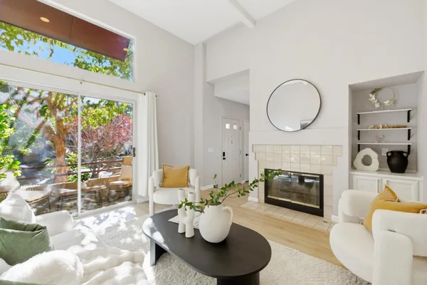 a living room with furniture a fireplace and a floor to ceiling window