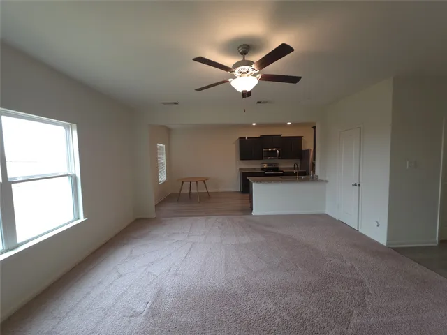 a view of a livingroom with a ceiling fan and window