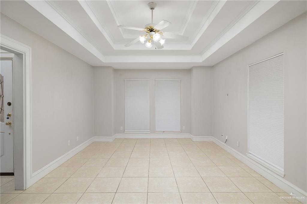 1204 East Jackson Avenue Pharr, TX 78577 - Photo 3 of 18 Unfurnished room featuring a tray ceiling, ceiling fan, light tile patterned floors, and ornamental molding