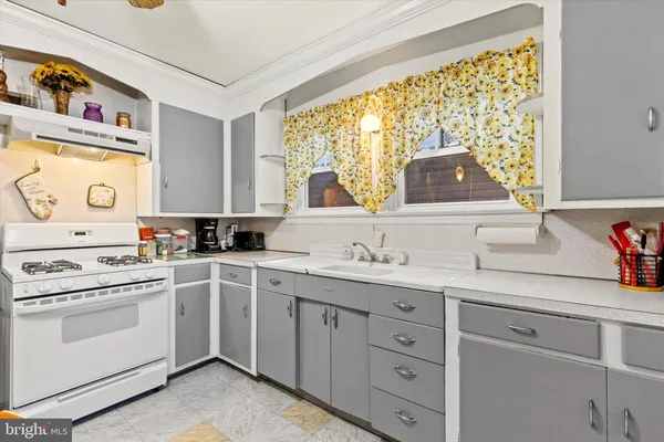 a kitchen with cabinets appliances a sink and a window