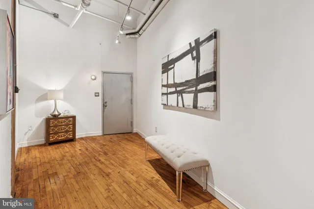 a view of a hallway with wooden floor and staircase