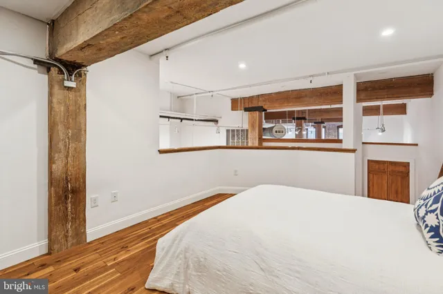 a bedroom with a bed and wooden floor