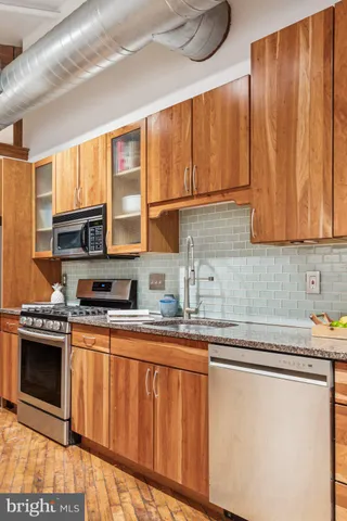 a kitchen with stainless steel appliances granite countertop a sink and cabinets