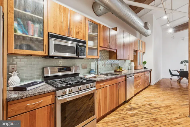 a large kitchen with lots of counter top space and wooden floor