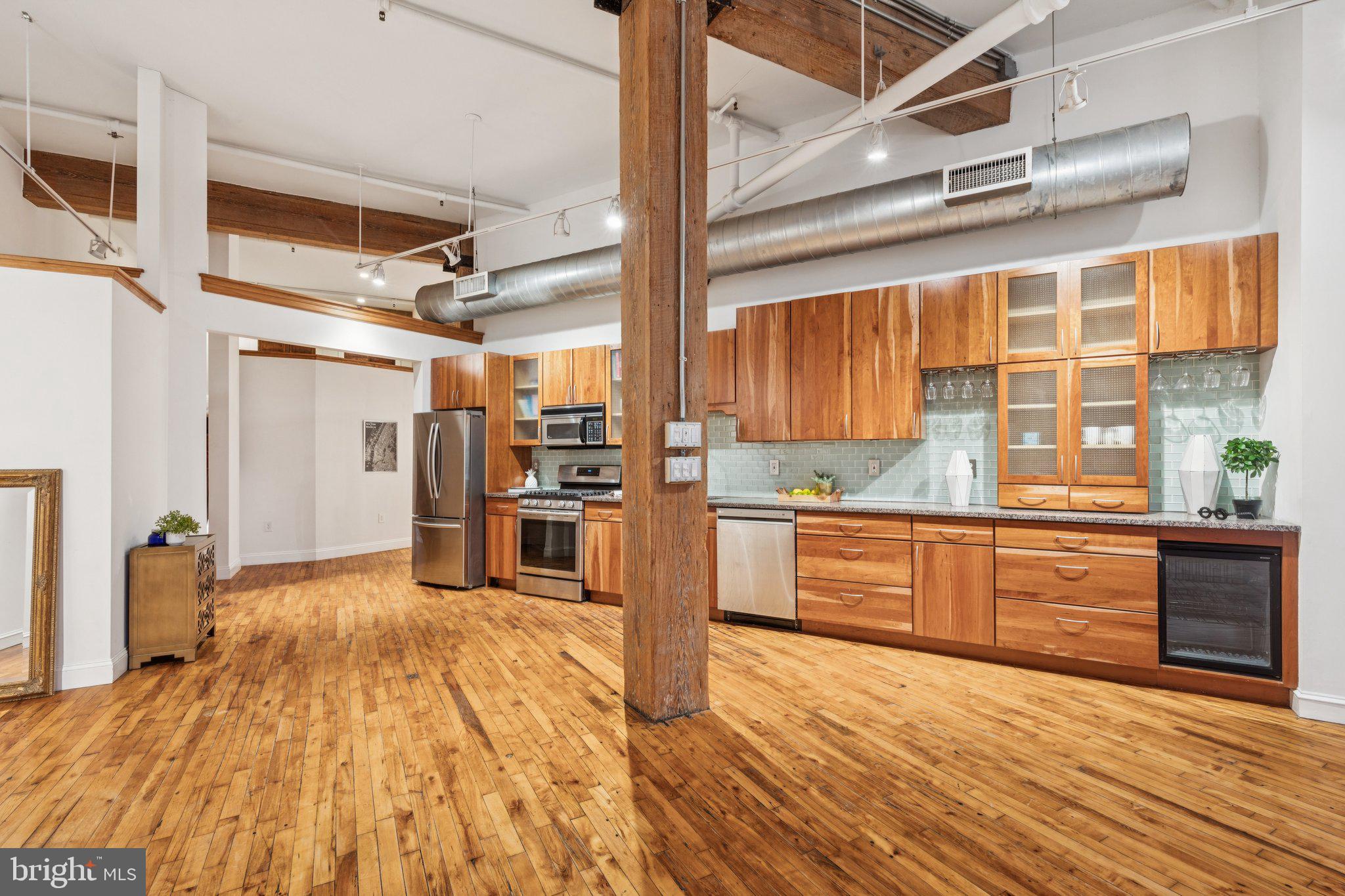 428 North 13th Street, Unit 3F Philadelphia, PA 19123 - Photo 35 of 48 a kitchen with stainless steel appliances wooden floor and large windows