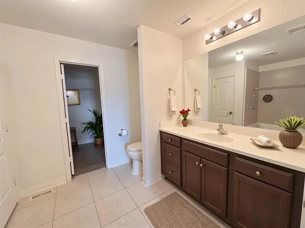 a spacious bathroom with a granite countertop sink mirror and toilet
