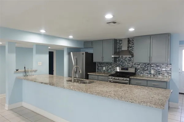 a large kitchen with kitchen island a sink stainless steel appliances and cabinets