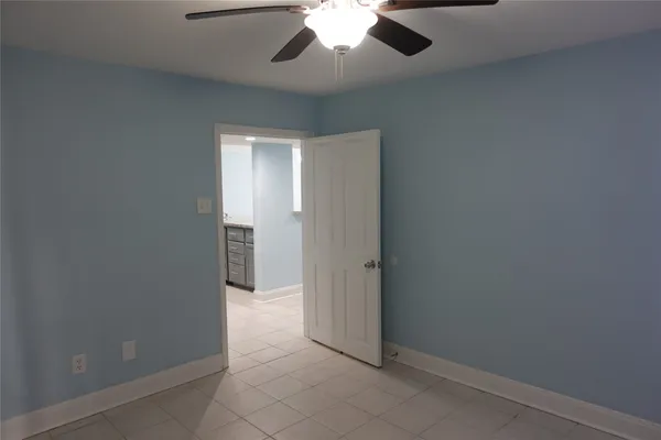 a view of empty room with window and ceiling fan