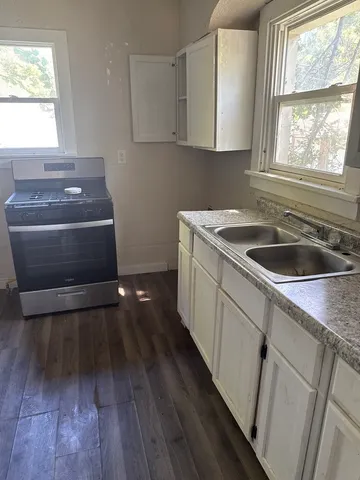 a kitchen with sink window and cabinets