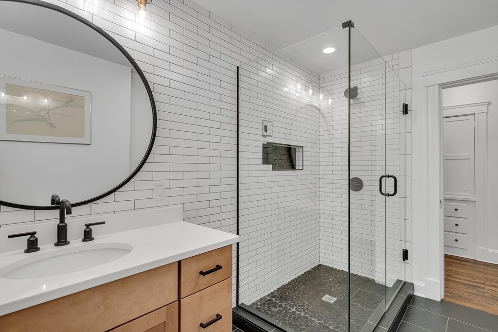 30 Perkins Street, Unit 1 Newton, MA 02465 - Photo 19 of 34 a bathroom with a sink a glass door shower and a mirror