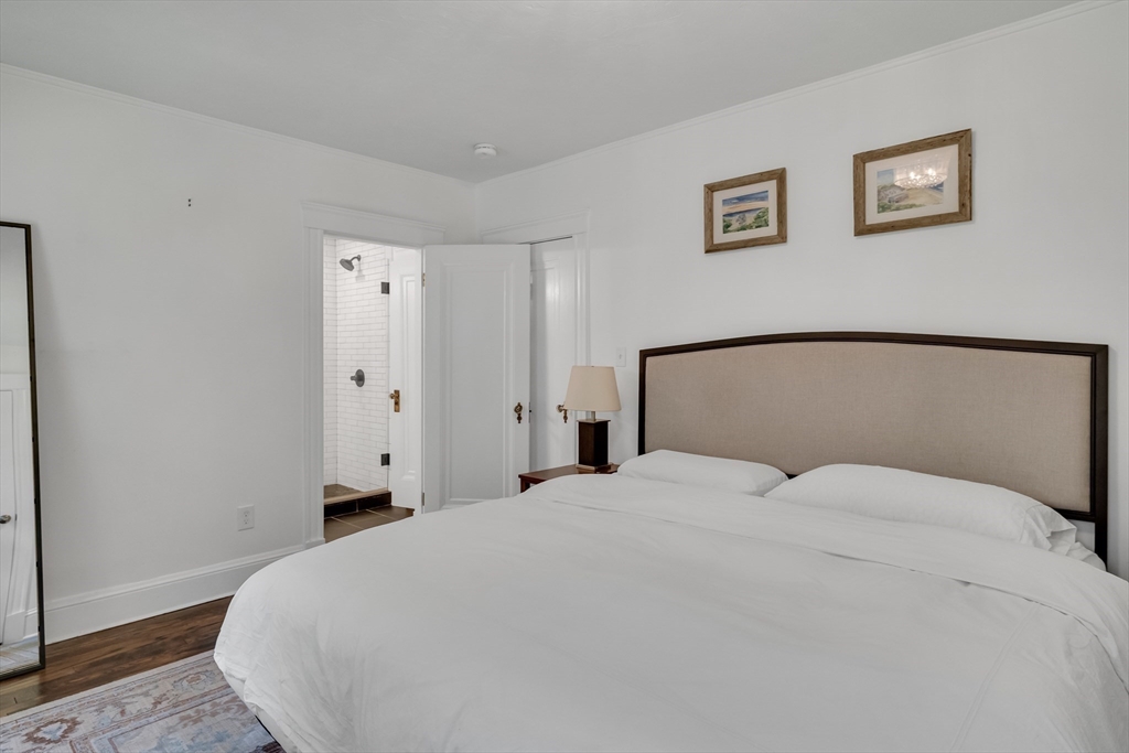 30 Perkins Street, Unit 1 Newton, MA 02465 - Photo 28 of 34 a bedroom with a bed and painting on the wall