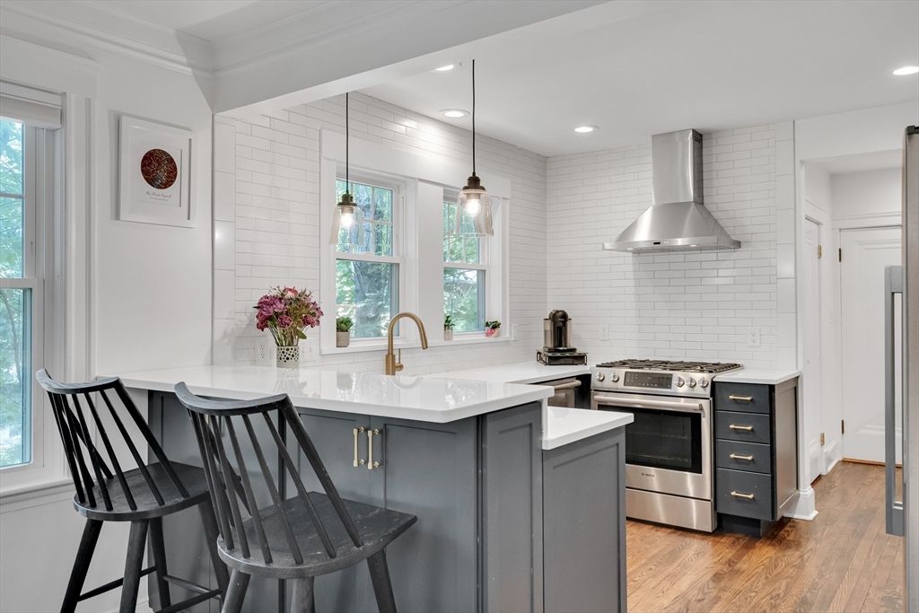 30 Perkins Street, Unit 1 Newton, MA 02465 - Photo 5 of 34 a kitchen with stainless steel appliances kitchen island granite countertop a stove a sink and a refrigerator