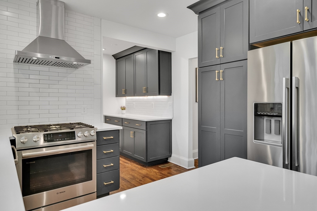 30 Perkins Street, Unit 1 Newton, MA 02465 - Photo 6 of 34 a kitchen with granite countertop stainless steel appliances and wooden cabinets