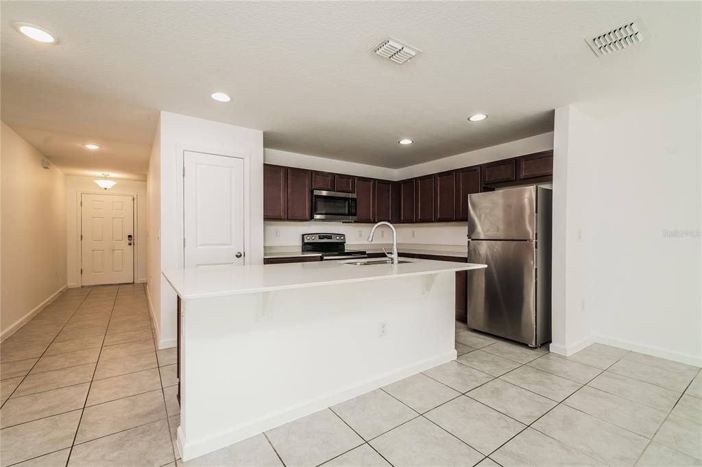 1473 Lucerne Loop Road Northeast Winter Haven, FL 33881 - Photo 22 of 25 a kitchen with stainless steel appliances a refrigerator sink and microwave