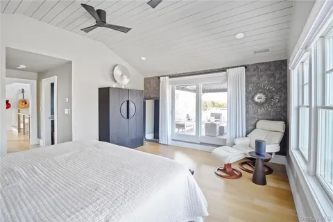 a bedroom with a bed a large window and furniture