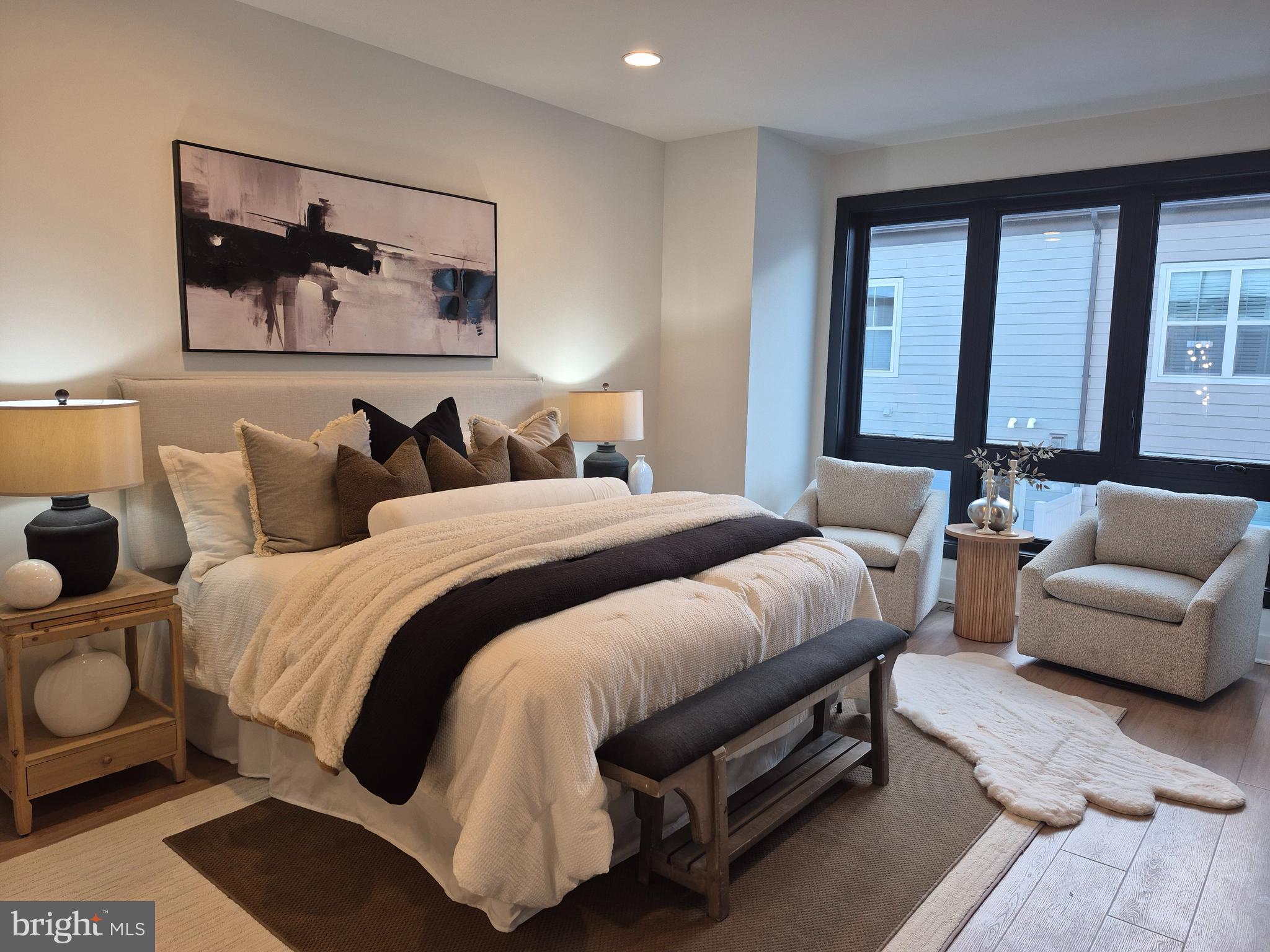 14944 Dispatch Street, Unit 2 Rockville, MD 20850 - Photo 18 of 36 a spacious bedroom with a bed a couch and a painting on the wall