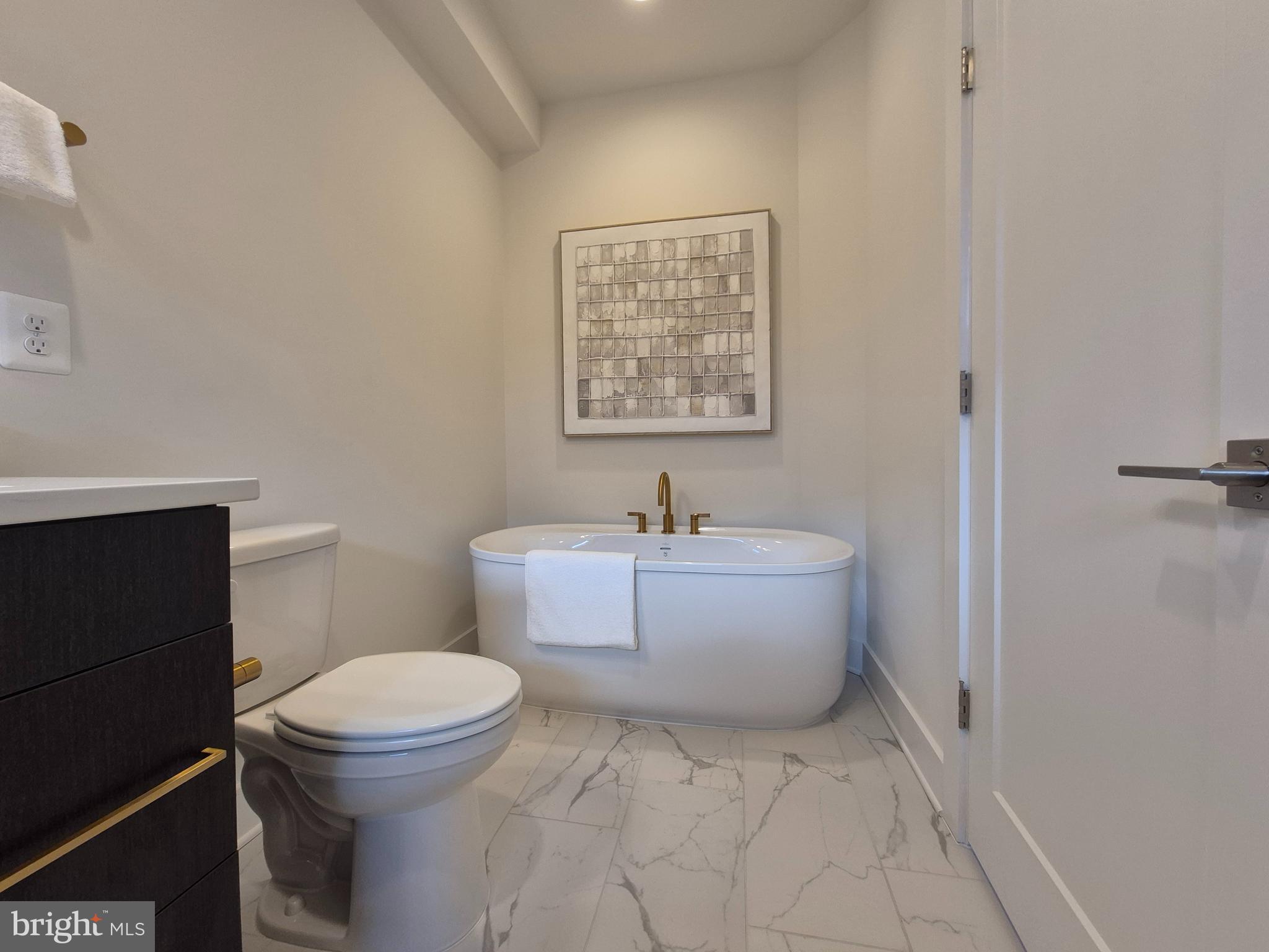 14944 Dispatch Street, Unit 2 Rockville, MD 20850 - Photo 21 of 36 a bathroom with a white toilet sitting next to a white tub