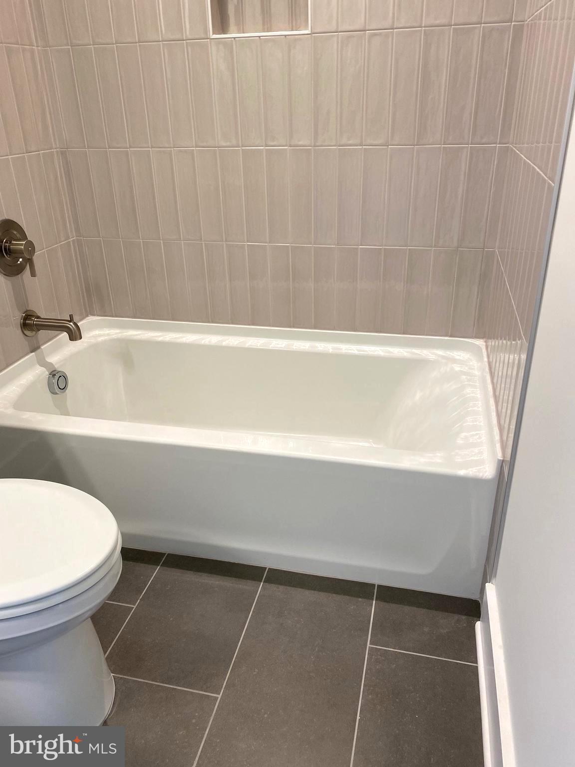 14944 Dispatch Street, Unit 2 Rockville, MD 20850 - Photo 26 of 36 a bathroom with a toilet and a bathtub